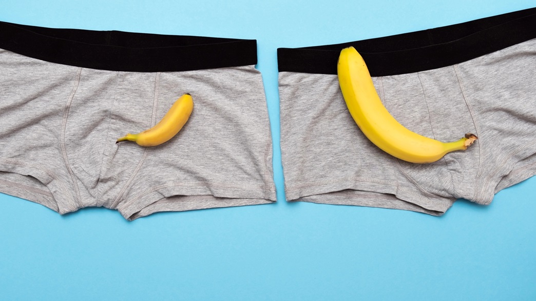 zwei Bananen liegen auf 2 Boxxershorts vor blauem Hintergrund